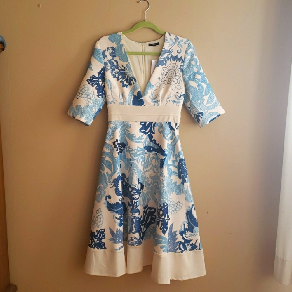 Deep V-neck dress with fitted waist and full skirt.  Sleeves end at elbow.